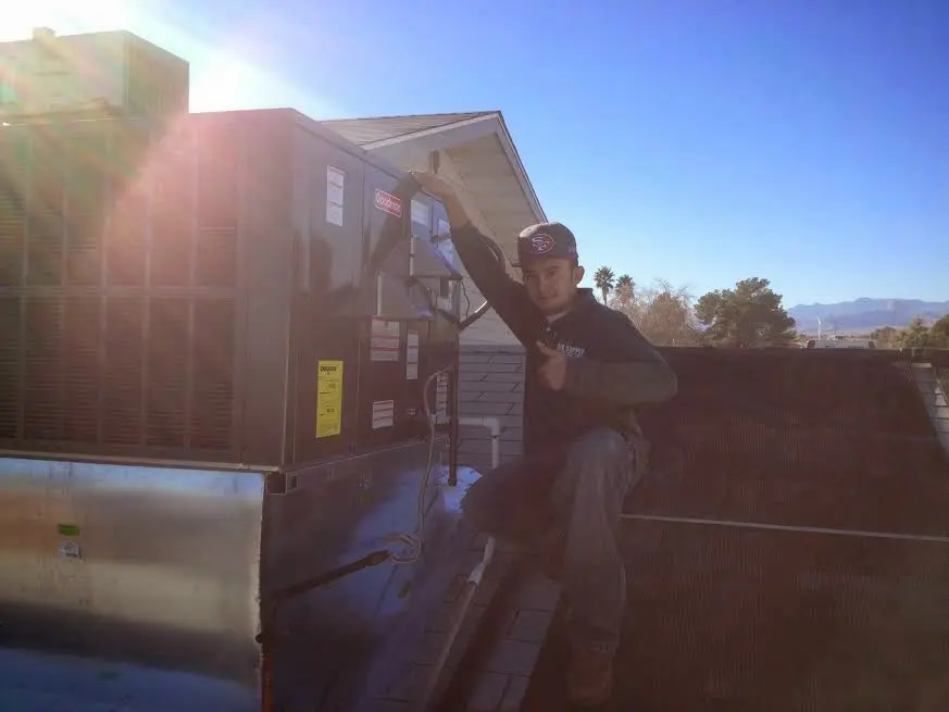 HVAC technician performing Heat Pump Repair on a rooftop unit in Washingtonville